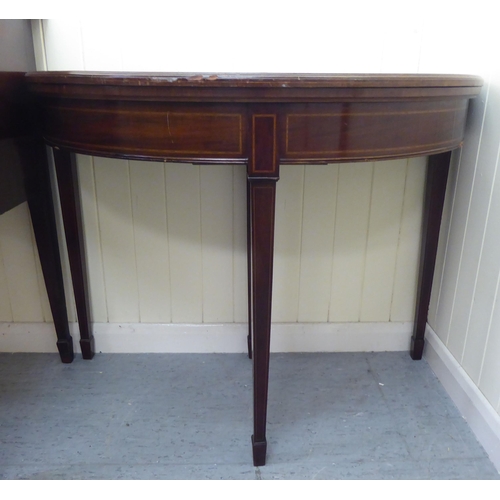 327 - An Edwardian Georgian style string inlaid mahogany demi-lune card table, raised on square, tapered l... 
