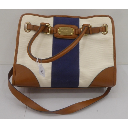 330 - A ladies Michael Kors brown leather, cream coloured and dark blue fabric handbag
