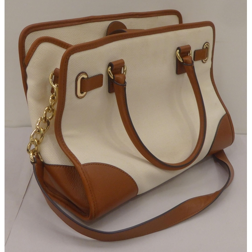 330 - A ladies Michael Kors brown leather, cream coloured and dark blue fabric handbag