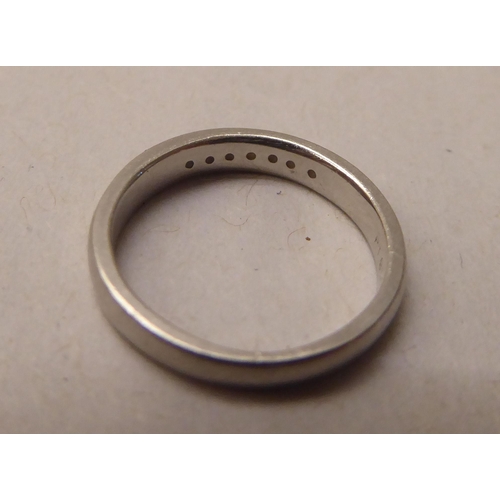 341 - A platinum band ring, set with seven small diamonds