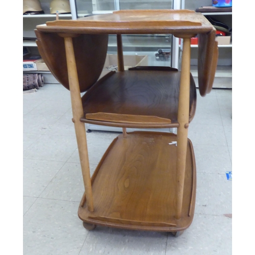 348 - An Ercol light elm, two tier tea trolley with fall flaps, raised on casters&nbsp; 30