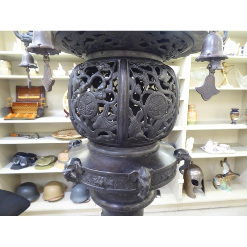 351 - A Japanese bronze finished, metal temple censer with a pagoda top, over a pierced bowl, on a pedesta... 