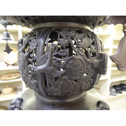 351 - A Japanese bronze finished, metal temple censer with a pagoda top, over a pierced bowl, on a pedesta... 