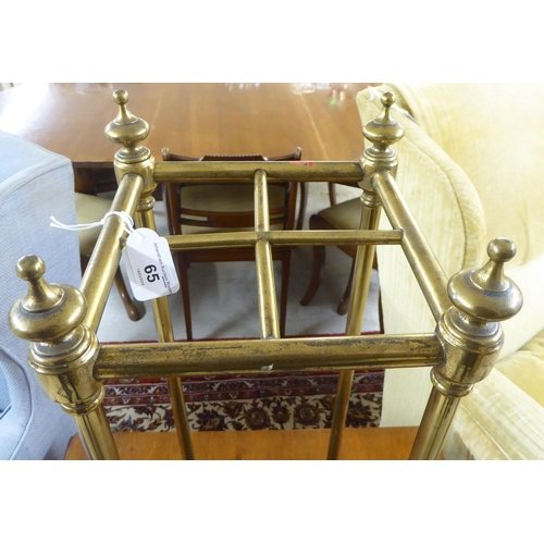 65 - An early 20thC lacquered brass four division stickstand with a cast iron tray  24