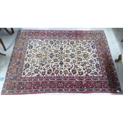 70 - A Persian rug, decorated with flora and foliate designs, on a multi-coloured ground  58