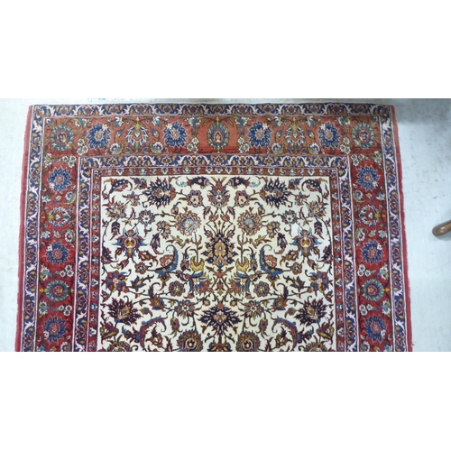 70 - A Persian rug, decorated with flora and foliate designs, on a multi-coloured ground  58