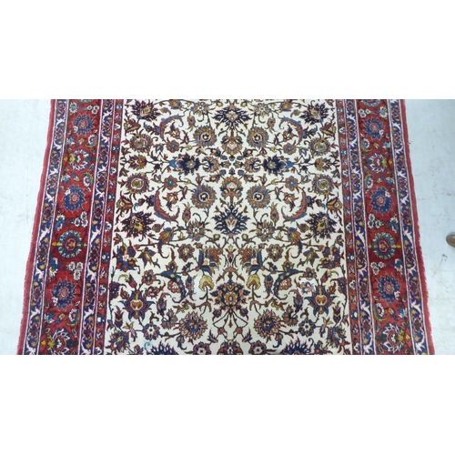 70 - A Persian rug, decorated with flora and foliate designs, on a multi-coloured ground  58