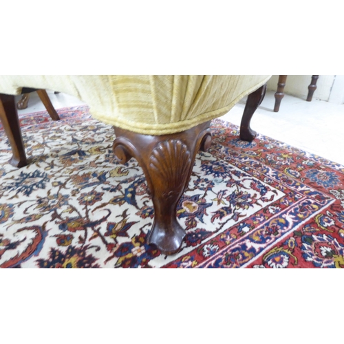 71 - An early 20thC Georgian style and later fabric upholstered, wingback, enclosed armchair, raised on C... 