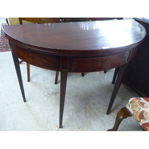 76 - A George III string inlaid mahogany D-end tea table, raised on a rear gateleg action and square, tap... 