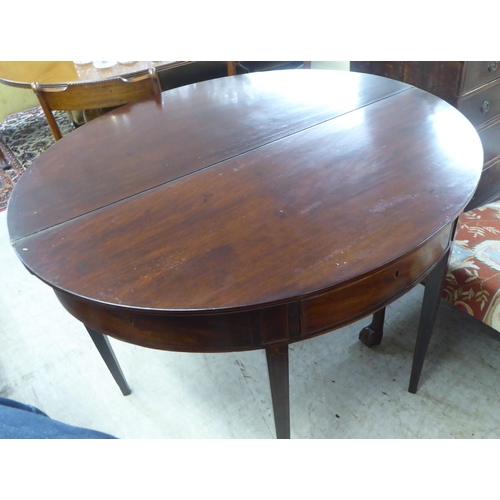 76 - A George III string inlaid mahogany D-end tea table, raised on a rear gateleg action and square, tap... 