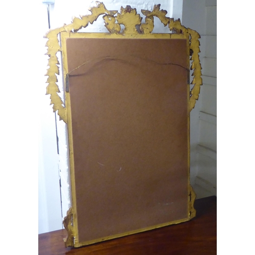 87 - A 20thC mirror, the plate set in a vase and foliate moulded gilt frame  35