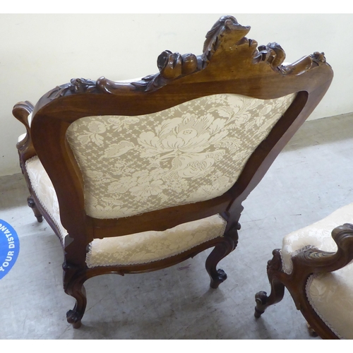 93 - A pair of late Victorian style walnut showwood framed open arm salon chairs, upholstered in two tone... 