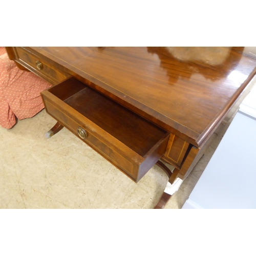 94 - A modern reproduction of a Georgian string inlaid mahogany sofa table, raised on lyre shaped ends, s... 