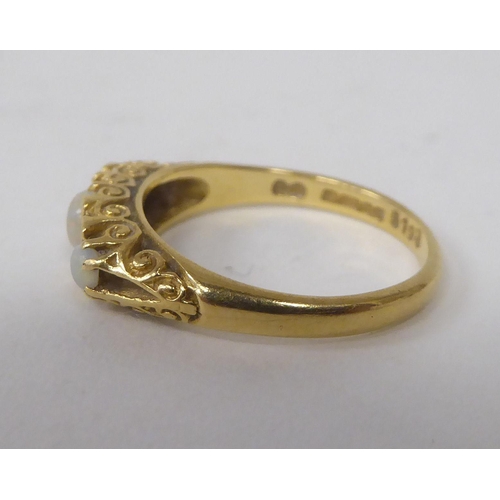 165 - An 18ct gold ring, set with three cabochon opals, interspersed with diamonds&nbsp;