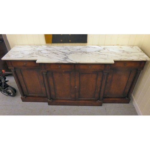 173 - A Regency style mahogany breakfront sideboard with applied pilasters and a mottled grey/white marble... 