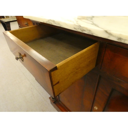 173 - A Regency style mahogany breakfront sideboard with applied pilasters and a mottled grey/white marble... 