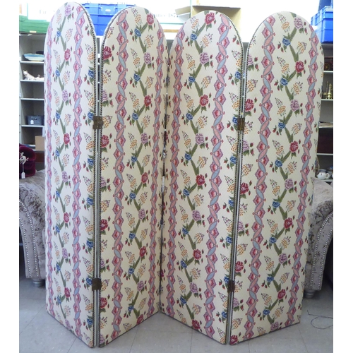 170 - A modern four fold, round arch topped room screen, stud upholstered with floral patterned and stripe... 