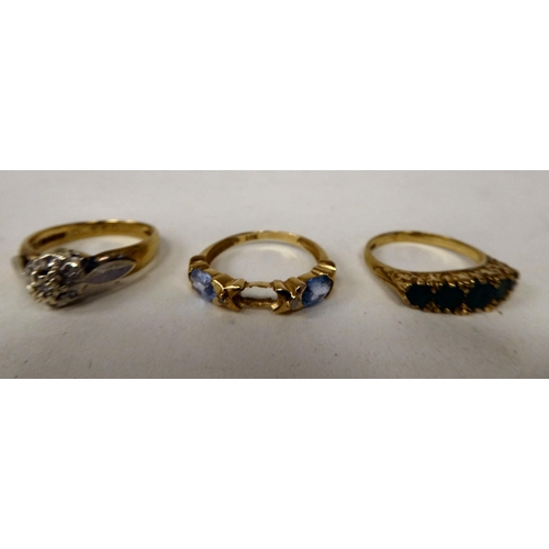 129 - Three variously designed, 9ct gold rings: to include one set with aquamarine coloured stones