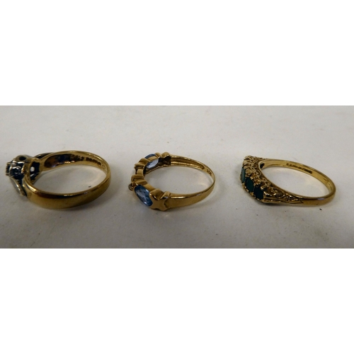 129 - Three variously designed, 9ct gold rings: to include one set with aquamarine coloured stones