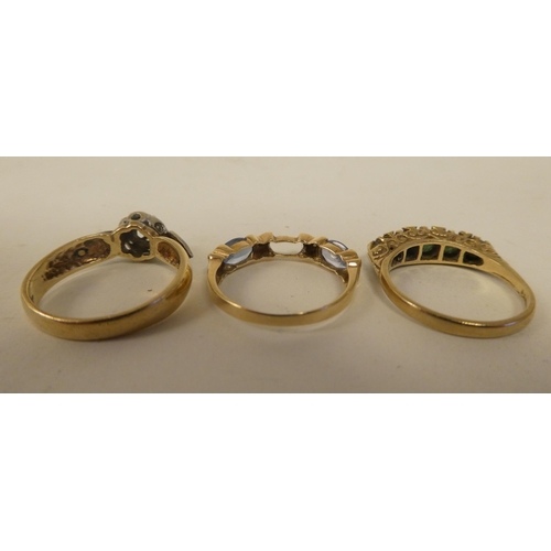 129 - Three variously designed, 9ct gold rings: to include one set with aquamarine coloured stones