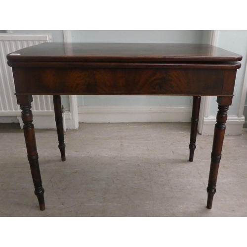 130 - A mid Victorian mahogany tea table, the foldover top with round corners, raised on ring turned, tape... 