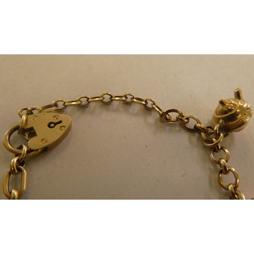 146 - Two 9ct gold, gold coloured and other metal charms, on bracelets, one with a padlock clasp