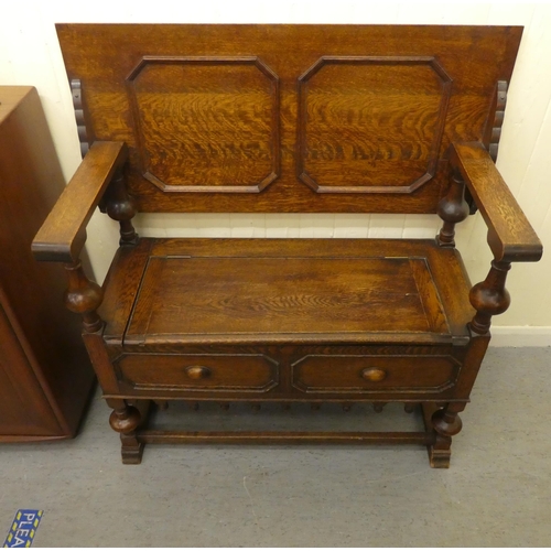192 - A 1930s oak monks bench with a carved lift and slide back, over a hinged seat, raised on splayed fee... 