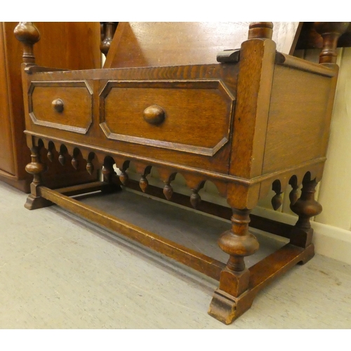 192 - A 1930s oak monks bench with a carved lift and slide back, over a hinged seat, raised on splayed fee... 