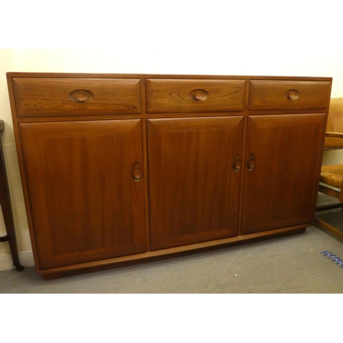 193 - An Ercol mid brown elm sideboard with three drawers and three doors, on a plinth&nbsp; 37