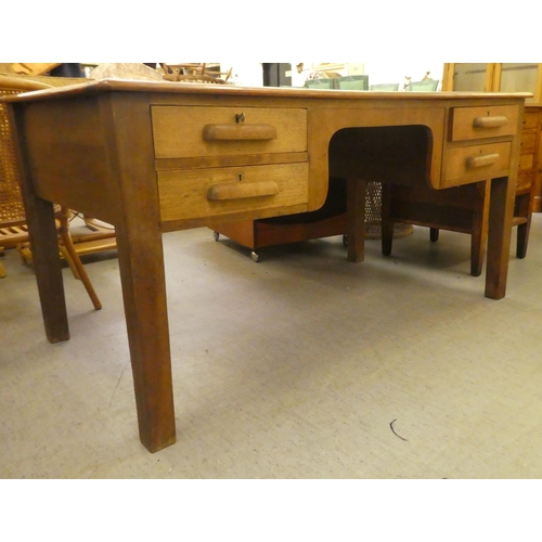 197 - A 1930s oak desk with four drawers, raised on block legs&nbsp; 30