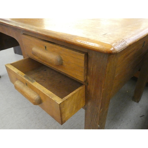 197 - A 1930s oak desk with four drawers, raised on block legs&nbsp; 30