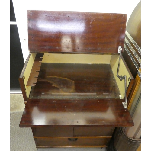 202 - A 1950s fruitwood cocktail cabinet with a rise and fall top, over two doors, raised on casters  38