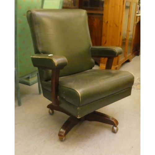 206 - A mid 20thC faux green hide upholstered swivel office chair, raised on a splayed pedestal base