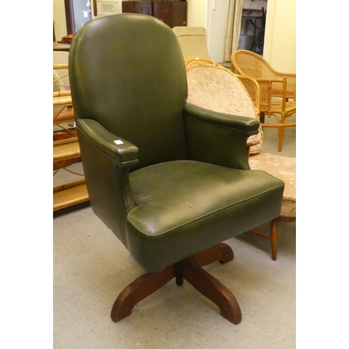 211 - A mid 20thC faux green hide upholstered swivel office chair, raised on a splayed pedestal base
