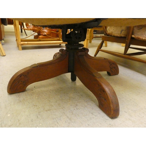 211 - A mid 20thC faux green hide upholstered swivel office chair, raised on a splayed pedestal base