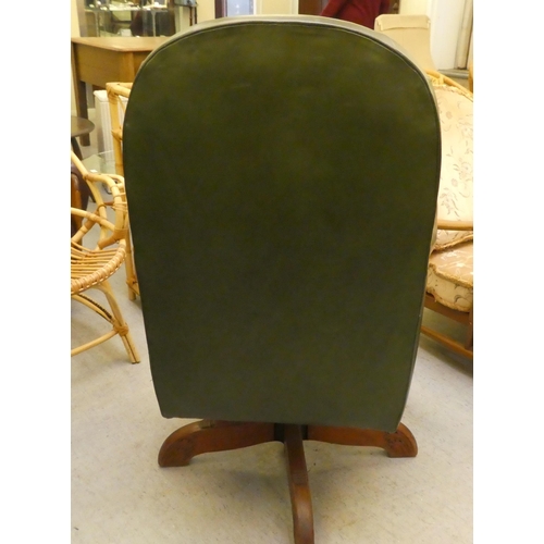 211 - A mid 20thC faux green hide upholstered swivel office chair, raised on a splayed pedestal base