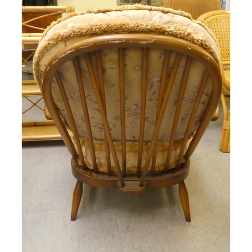 212 - An Ercol mid brown elm spindle back armchair, raised on turned legs&nbsp;
