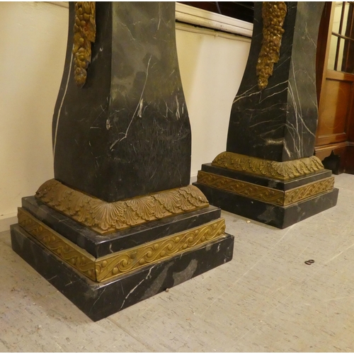 25 - A pair of 19thC Continentally inspired, modular, marble pedestals of square, tapered form with gilt ... 