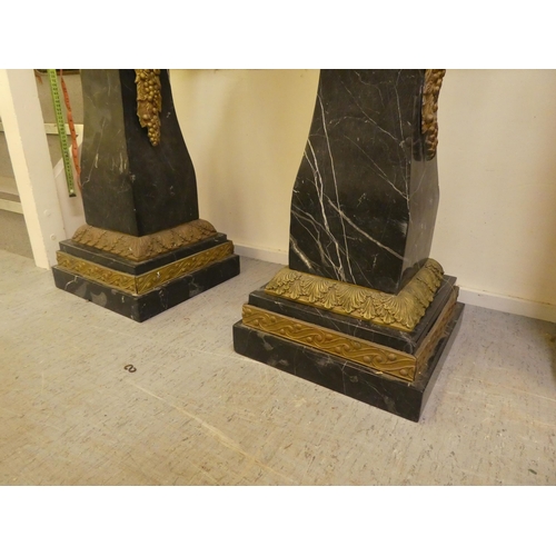 25 - A pair of 19thC Continentally inspired, modular, marble pedestals of square, tapered form with gilt ... 