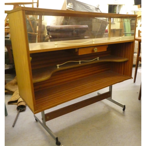 261 - A 1960s laminate bar with a glazed upper section, raised on metal legs  38