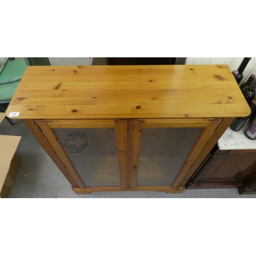 262 - A modern stained pine bookcase with two glazed doors, on a bracket plinth  48