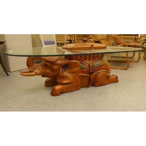 265 - A modern teak framed coffee table, the base fashioned as an elephant with a glass top  14