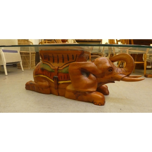 265 - A modern teak framed coffee table, the base fashioned as an elephant with a glass top  14