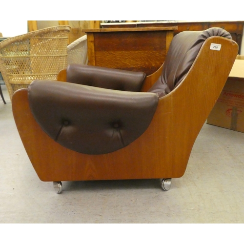 268 - A 1960/70s G-Plan teak framed easy chair with a faux brown hide upholstered back and seat