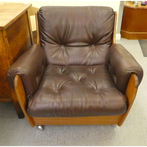 268 - A 1960/70s G-Plan teak framed easy chair with a faux brown hide upholstered back and seat