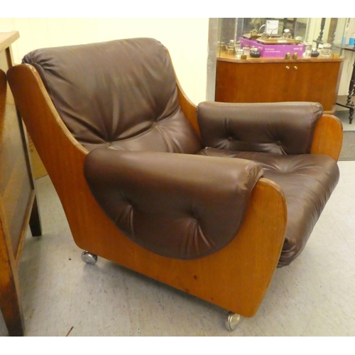 268 - A 1960/70s G-Plan teak framed easy chair with a faux brown hide upholstered back and seat