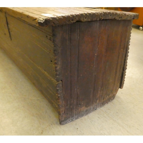 270 - A mid 18thC boarded oak chest with a hinged lid, raised on planked feet  17