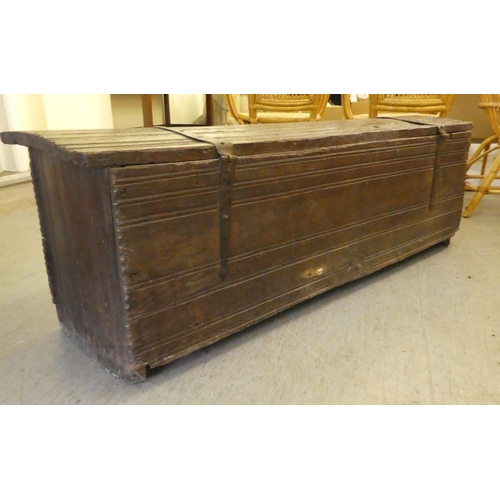 270 - A mid 18thC boarded oak chest with a hinged lid, raised on planked feet  17