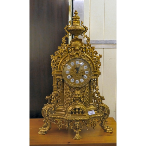 285 - A modern Victorian design, gilt metal cased mantel clock of ornate architectural design, faced by a ... 