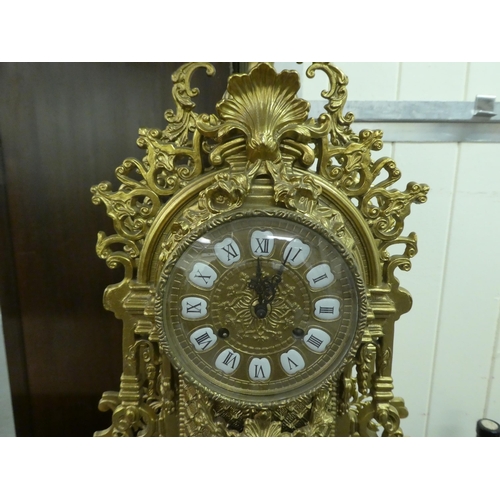 285 - A modern Victorian design, gilt metal cased mantel clock of ornate architectural design, faced by a ... 